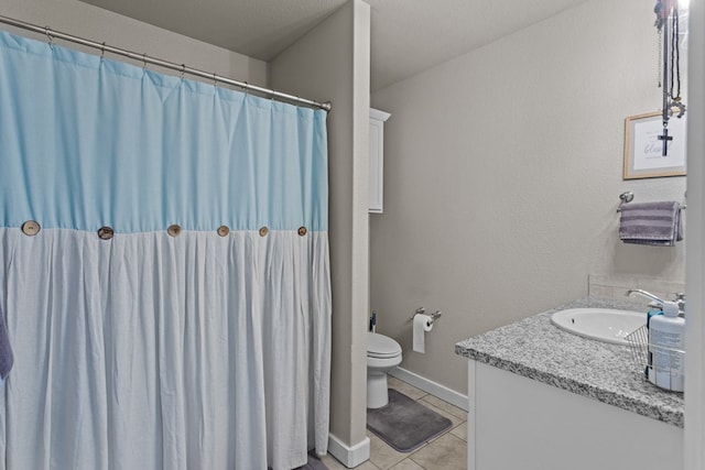 bathroom featuring vanity, tile patterned floors, and toilet