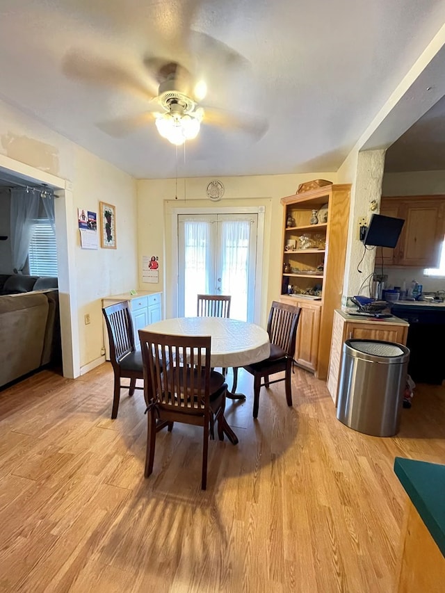 dining room with ceiling fan, light wood-type flooring, and french doors