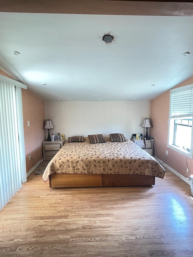 unfurnished bedroom with light hardwood / wood-style floors and lofted ceiling