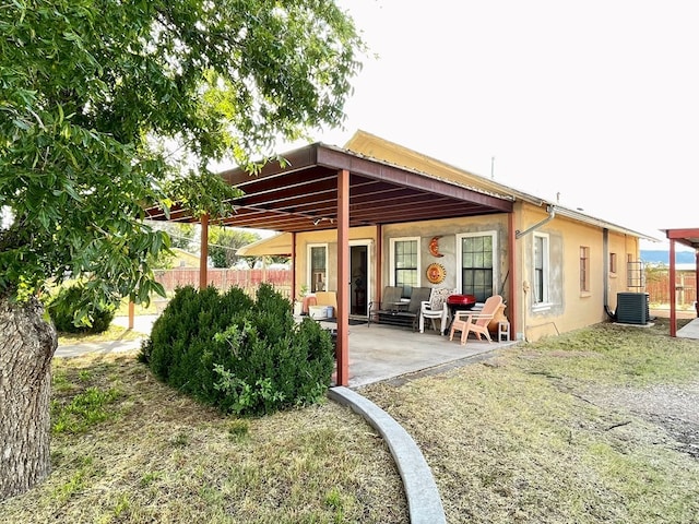 rear view of property with central air condition unit and a patio