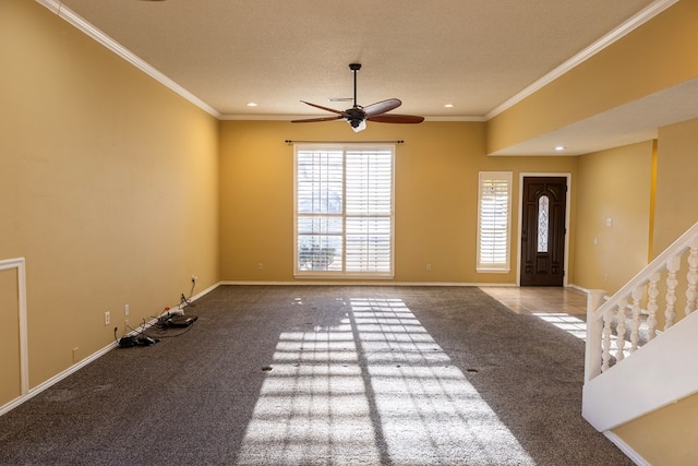 foyer entrance with carpet, crown molding, baseboards, and a textured ceiling