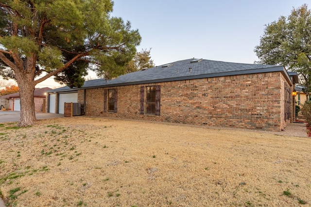 back of property featuring an attached garage and brick siding