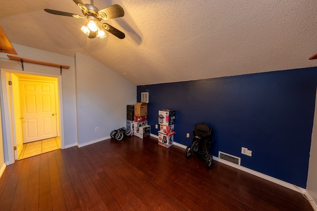 additional living space featuring lofted ceiling, wood-type flooring, visible vents, and a textured ceiling