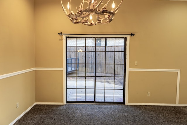 interior space featuring baseboards, carpet floors, and an inviting chandelier