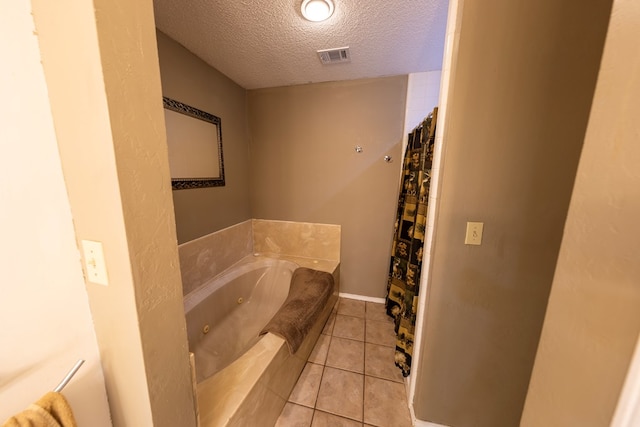 bathroom featuring curtained shower, visible vents, a textured ceiling, tile patterned flooring, and a tub with jets