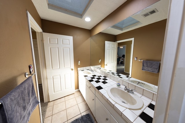 full bath featuring double vanity, tile patterned flooring, a sink, and visible vents