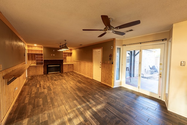 unfurnished living room with ornamental molding, dark wood-type flooring, and a textured ceiling