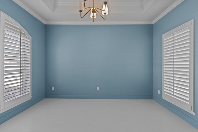 empty room featuring a notable chandelier, a tray ceiling, and ornamental molding