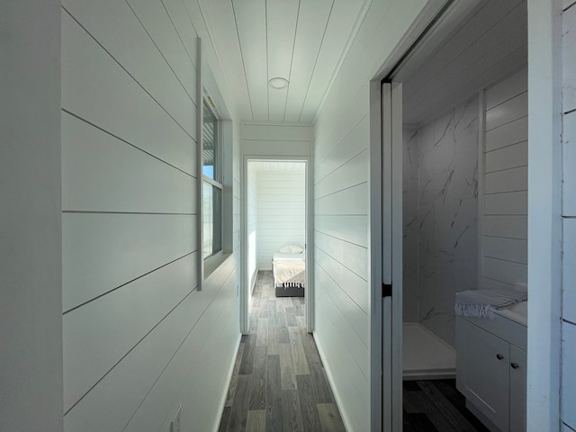 corridor featuring dark hardwood / wood-style floors and wood walls