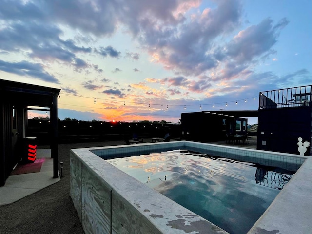 pool at dusk with a jacuzzi