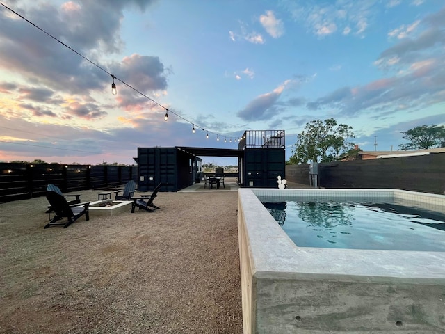 pool at dusk with a fire pit