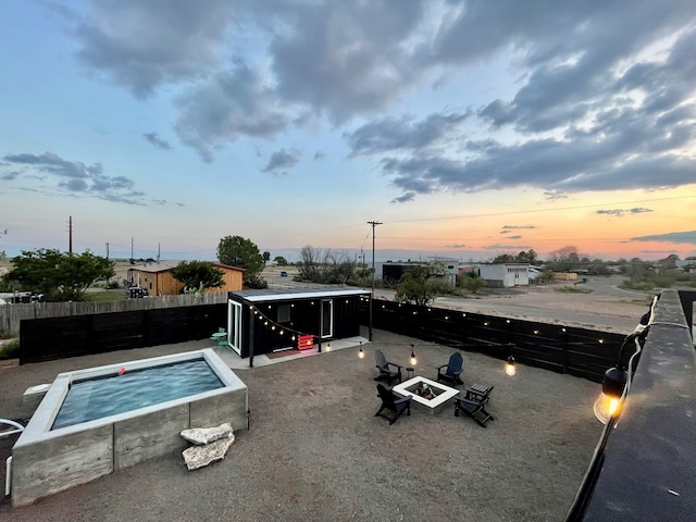 pool at dusk featuring an outdoor fire pit