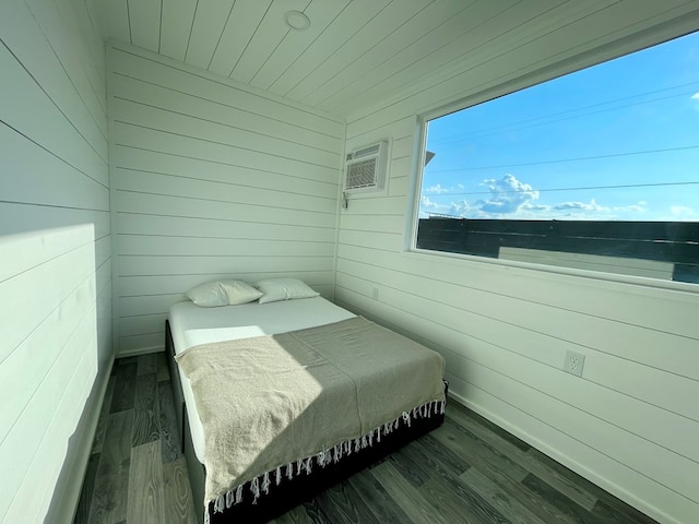 bedroom with dark hardwood / wood-style floors and wood walls