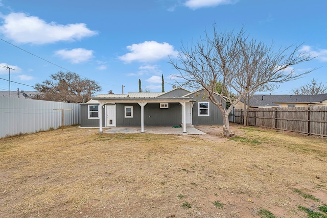 back of house featuring a lawn and a patio area