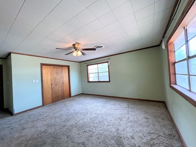 unfurnished bedroom featuring carpet, a closet, ceiling fan, and ornamental molding