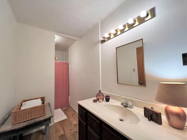 bathroom with hardwood / wood-style flooring, vanity, and ornamental molding