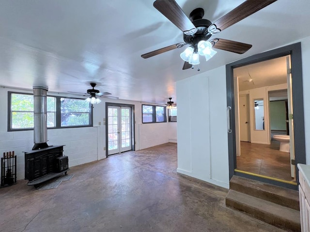 unfurnished living room with french doors and a wood stove