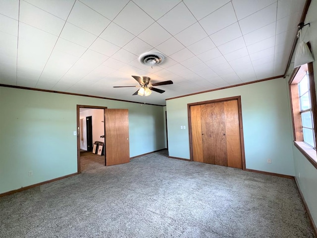 unfurnished bedroom featuring carpet floors, ceiling fan, and crown molding