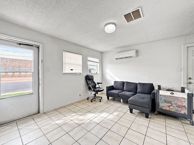 tiled living room featuring a textured ceiling, a wall mounted AC, and a healthy amount of sunlight