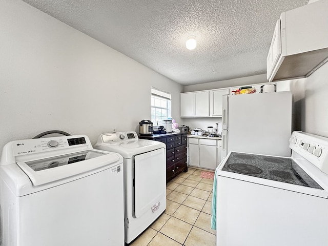 laundry room with washer and dryer, light tile patterned floors, and a textured ceiling