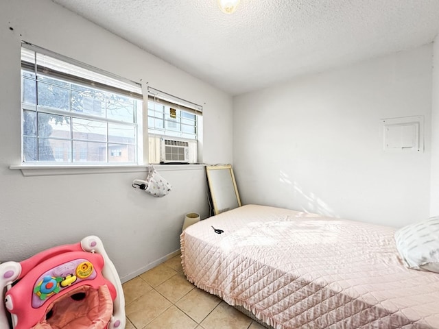 bedroom with light tile patterned floors, cooling unit, and a textured ceiling