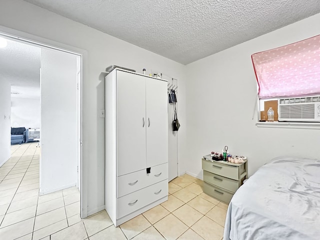 bedroom with a textured ceiling, cooling unit, and light tile patterned flooring