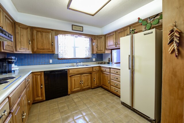 kitchen with a textured ceiling, decorative backsplash, sink, and white appliances