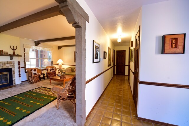 hall featuring beam ceiling and dark tile patterned floors