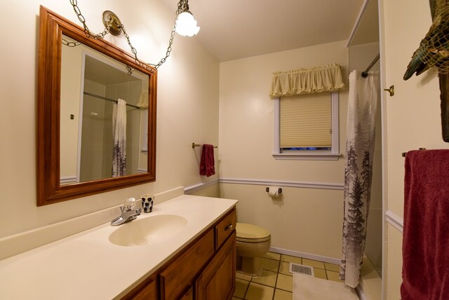 bathroom with tile patterned floors, walk in shower, vanity, and toilet