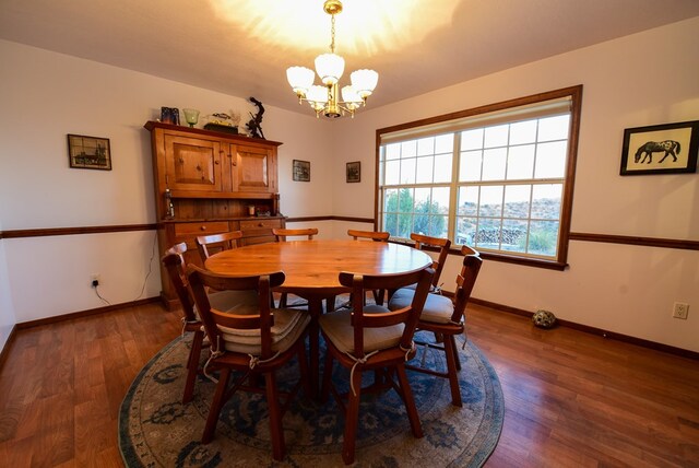 dining space with dark hardwood / wood-style flooring and a notable chandelier