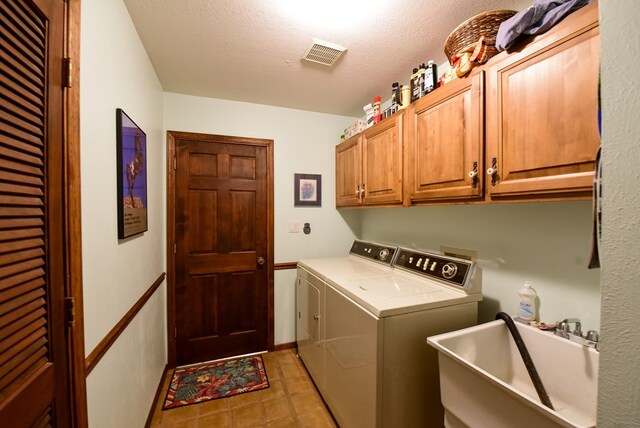 laundry room featuring sink, cabinets, a textured ceiling, and independent washer and dryer