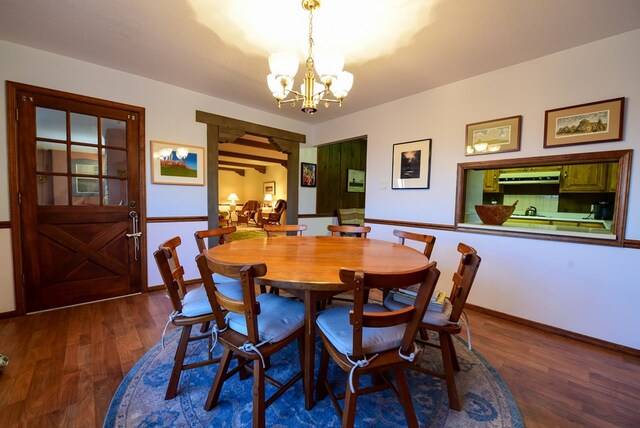 dining space featuring dark hardwood / wood-style flooring and an inviting chandelier