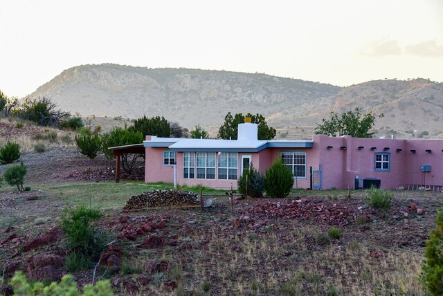 exterior space with central air condition unit, a mountain view, and a carport