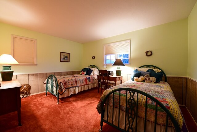 bedroom featuring wooden walls and carpet floors