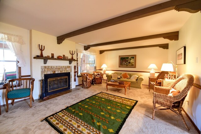 living room with beamed ceiling, carpet, and a tiled fireplace