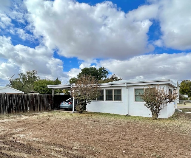 back of house featuring a carport