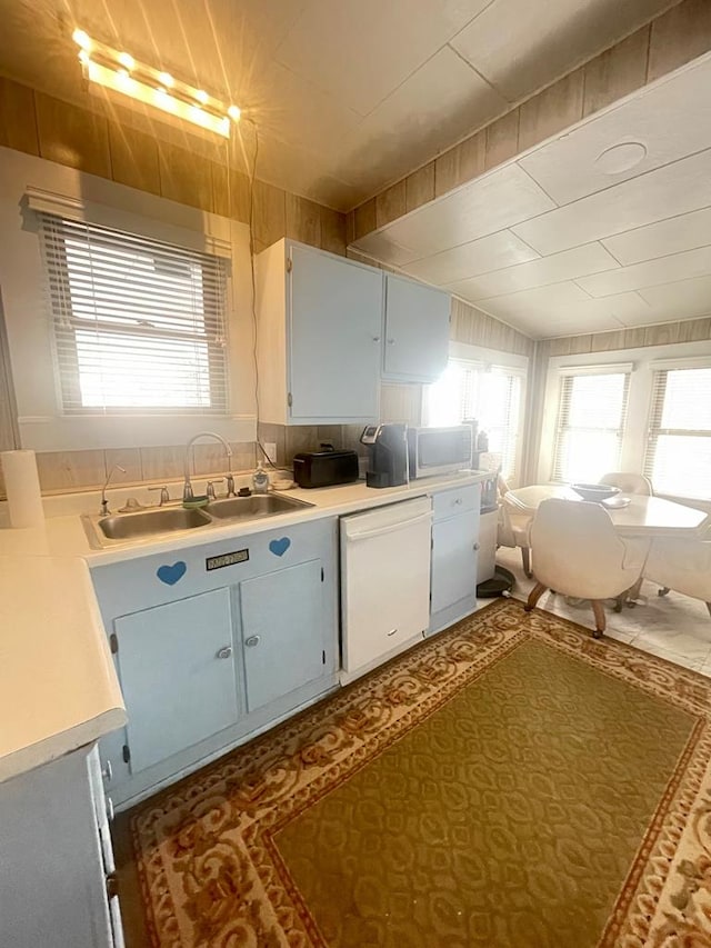 kitchen featuring backsplash, white cabinets, sink, and white dishwasher