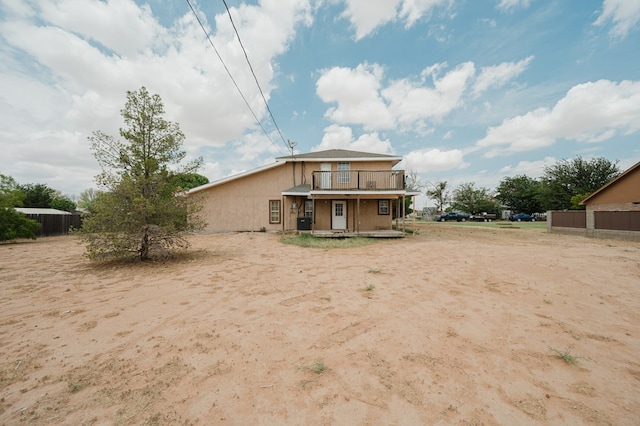 rear view of property with a balcony and a porch