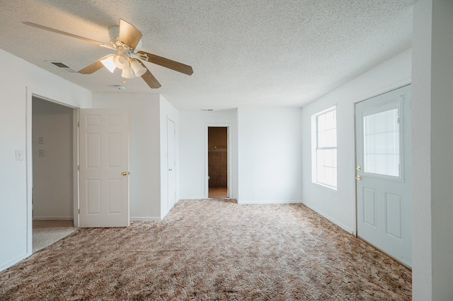 carpeted empty room featuring a textured ceiling and ceiling fan