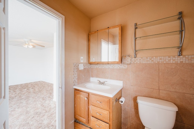 bathroom featuring vanity, ceiling fan, toilet, tile walls, and radiator heating unit