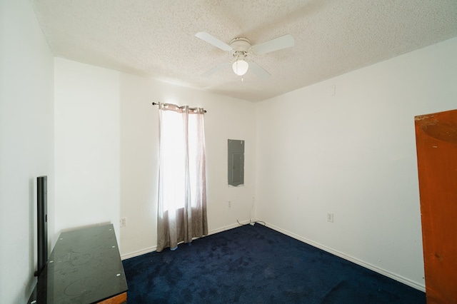 carpeted spare room featuring electric panel, ceiling fan, and a textured ceiling