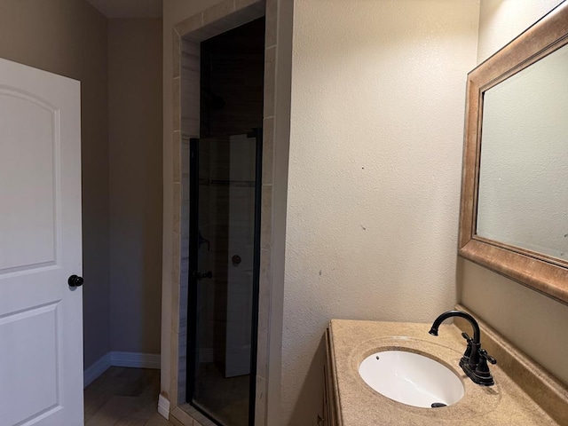 bathroom featuring vanity and an enclosed shower