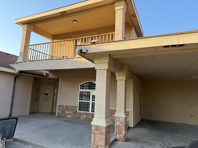 view of exterior entry with a balcony