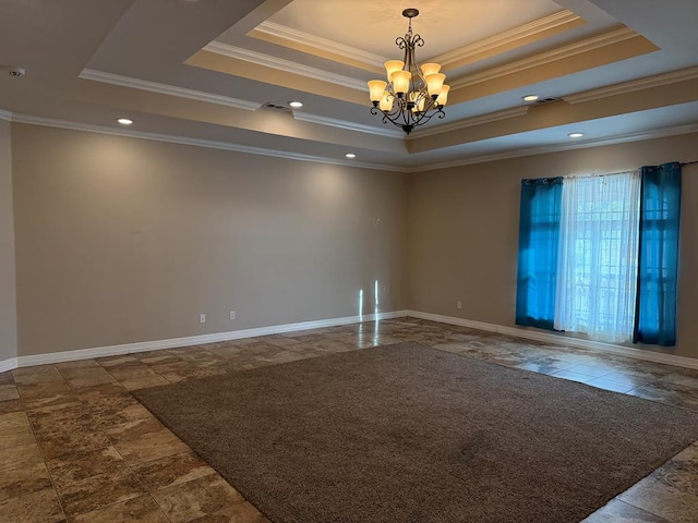 spare room with a notable chandelier, ornamental molding, and a tray ceiling