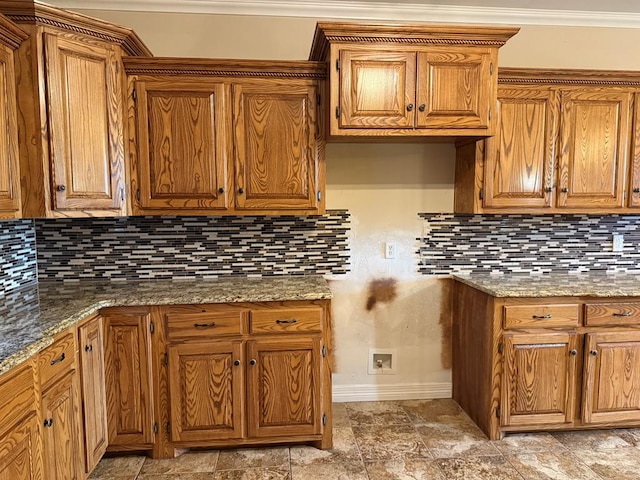 kitchen featuring backsplash, crown molding, and dark stone counters