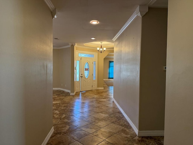 foyer entrance featuring crown molding and a chandelier