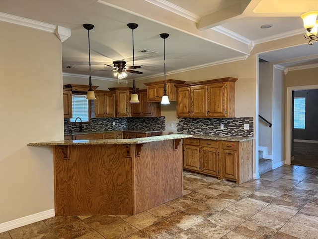 kitchen with plenty of natural light, kitchen peninsula, hanging light fixtures, and tasteful backsplash