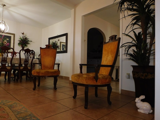 sitting room with dark tile patterned flooring and a chandelier