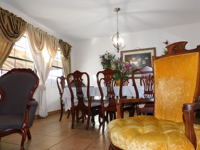 dining area featuring tile patterned floors and an inviting chandelier