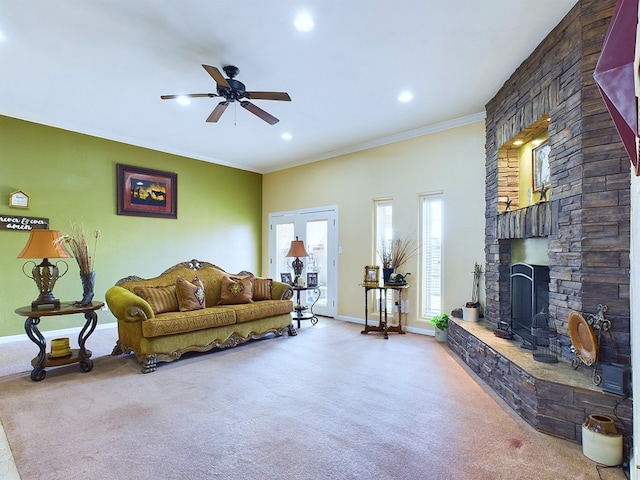 carpeted living room with a fireplace, crown molding, and ceiling fan